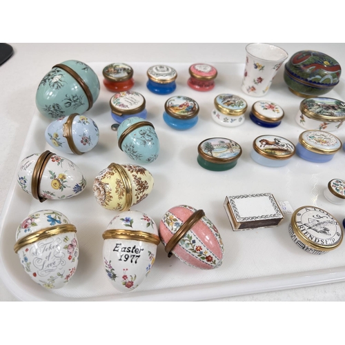 491 - A collection of Bilston and other painted enamel pots, eggs etc