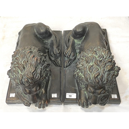 50 - A pair of good sized bronzed composition threshold lions reclining, length 45cm