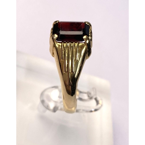 617 - An 18 carat hallmarked gold gent's ring set large cushion cut garnet coloured stone. 6gm, size W/X