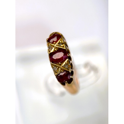 618 - An 18 carat hallmarked gold ring set with 3 garnets and diamond chips, 5.5 gm, size L