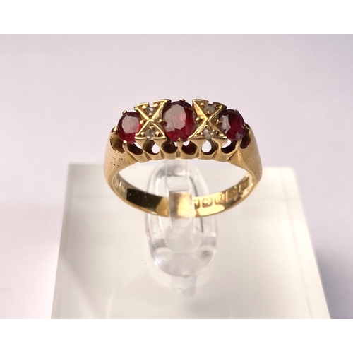 618 - An 18 carat hallmarked gold ring set with 3 garnets and diamond chips, 5.5 gm, size L