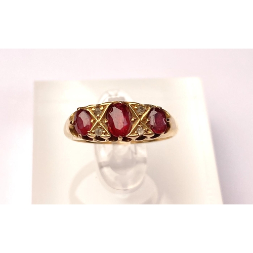 618 - An 18 carat hallmarked gold ring set with 3 garnets and diamond chips, 5.5 gm, size L