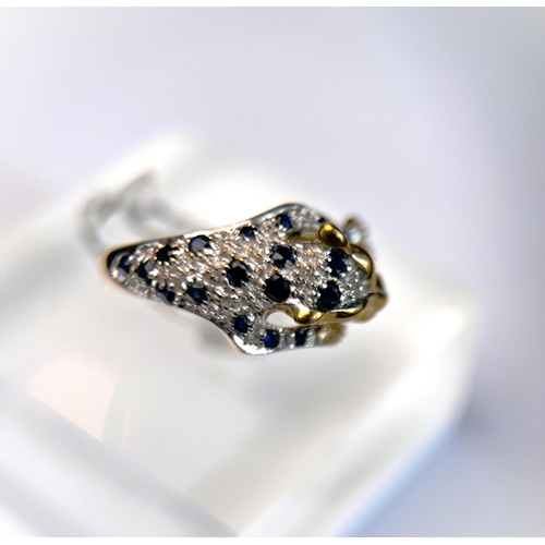 627 - A 9ct hallmarked gold ring in the form of a leopard pouncing set with small sapphires and illusion s... 