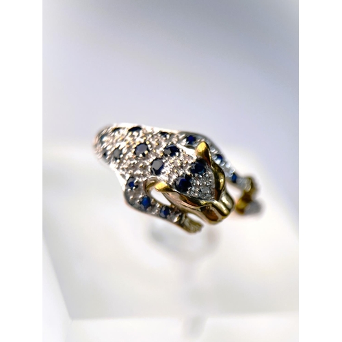 627 - A 9ct hallmarked gold ring in the form of a leopard pouncing set with small sapphires and illusion s... 