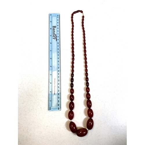 649 - A string of cherry amber bakelite graduating beads, total length 79cm, smallest bead 1cm, largest 3c... 