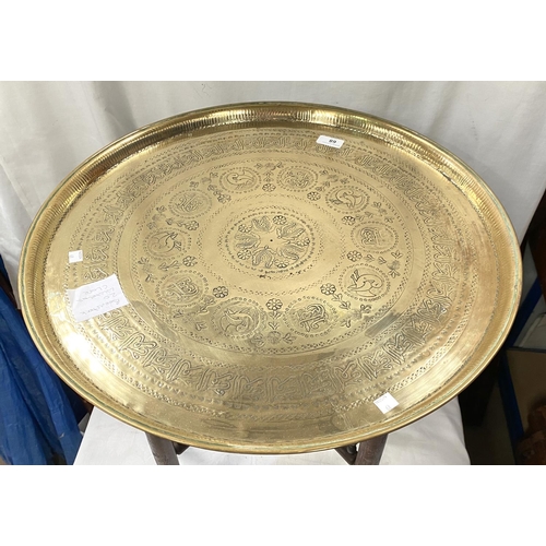 68 - A 19th / 20th century Eastern brass table with folding wood legs