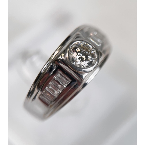 680 - A gent's white metal dress ring with central diamond approx. 0.7 carats on broad shank, each shoulde... 