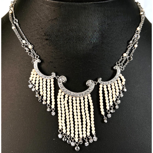 681 - A diamante and faux seed pearl necklace on triple chain with matching earrings, boxed