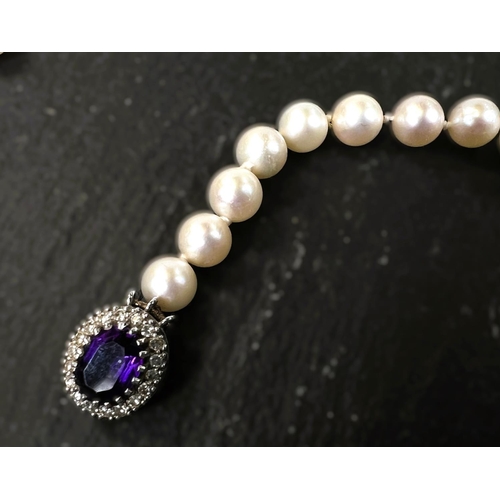 682 - A string of cultured pearls, knotted with 9ct hallmarked white gold clasp set with oval amethyst sur... 