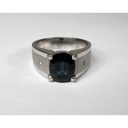 747 - A gent's dress ring with wide brushed white metal shank set with central sapphire (11.3 x 8.7mm) and... 