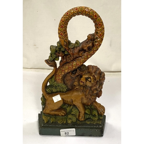 82 - A Victorian style cast iron door stop of a Lion fighting a Snake