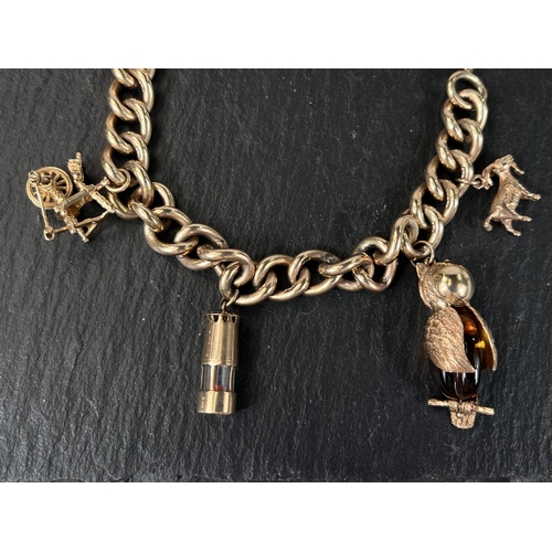 609 - A heavy curb chain charm bracelet with 9 carat hallmarked gold heart lock, 4 charms (2 x 9ct hmg) an... 