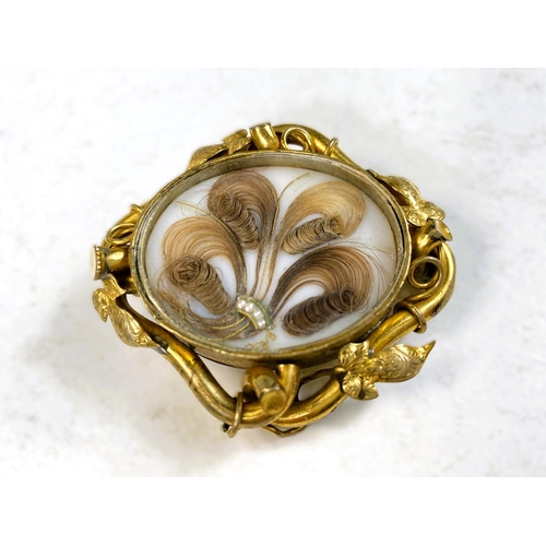 694 - A Victorian mourning brooch with gilt leaf border, hair display, monogrammed reverse, length 5.5cm 2... 