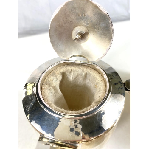 726 - An Arts & Crafts hallmarked silver planished silver tea service of circular form with bud finial... 