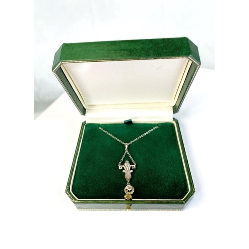 757 - An Art Deco cruciform style white metal pendant with diamond drop, tests as 9ct, on fine chain stamp... 