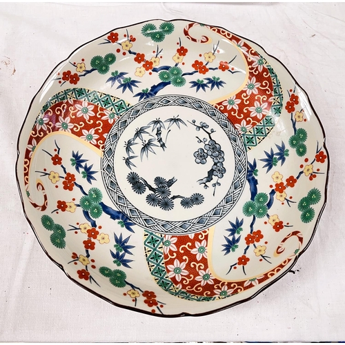 401A - An Imari shallow dish decorated in polychrome with flowers and branches, signature to base, dia. 30c... 