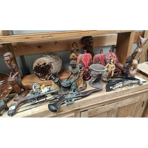 86 - An interesting collection of wooden carved tribal figures, resin and other African figures, hide, tr... 