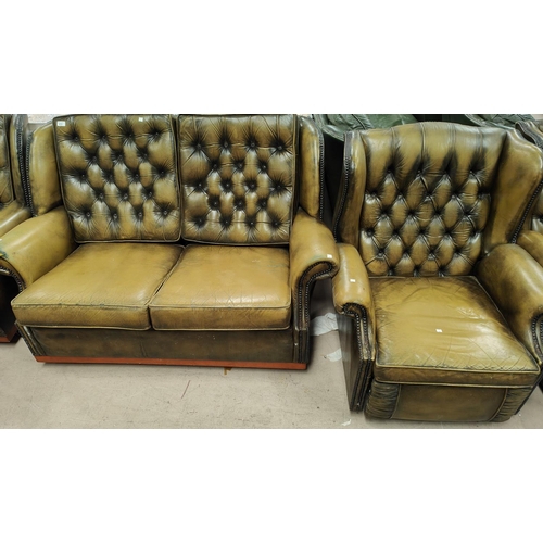 872 - A green leather effect Chesterfield style reclining armchair with deep button back with studded deco... 