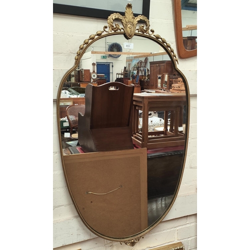 893 - An early 20th century gilt metal framed mirror in the Rococo style with beaded decoration to the rim... 