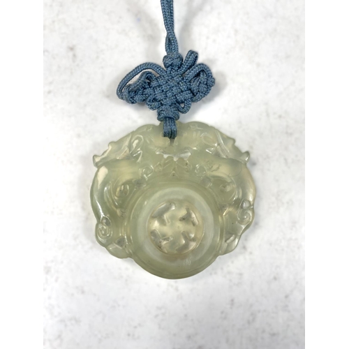 709 - A New Zeland Tiki nephrite jade pendant with carved face and a Chinese jade pendant 