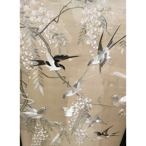 409 - A large Chinese embroidered picture depicting birds in branches, 137 x 51cm framed and glazed