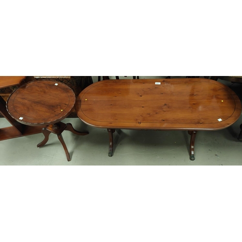 879 - A reproduction yew wood coffee table with rounded rectangular top and twin pedestals on splay feet; ... 