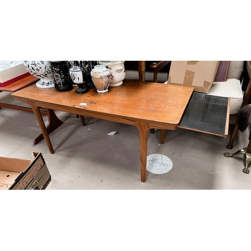 957 - A 1960's rectangular teak coffee table with leaves to each end; a similar table