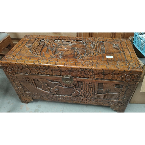 972 - An oriental camphor wood bedding box with extensive carved wood decoration, length