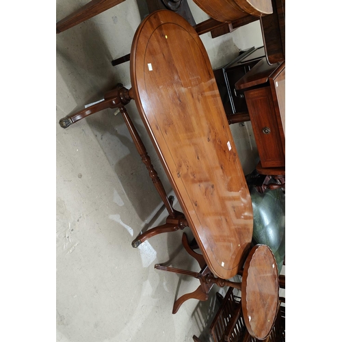 946 - A reproduction yew wood coffee table with rounded rectangular top and twin pedestals on splay feet; ... 