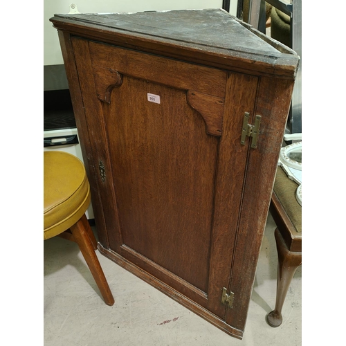 955 - An 18th Century oak corner cupboard with raised arch panel doors.