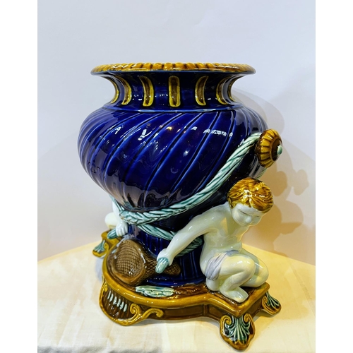 A large modern Majolica vase supported by two cherubs, height 30cm.