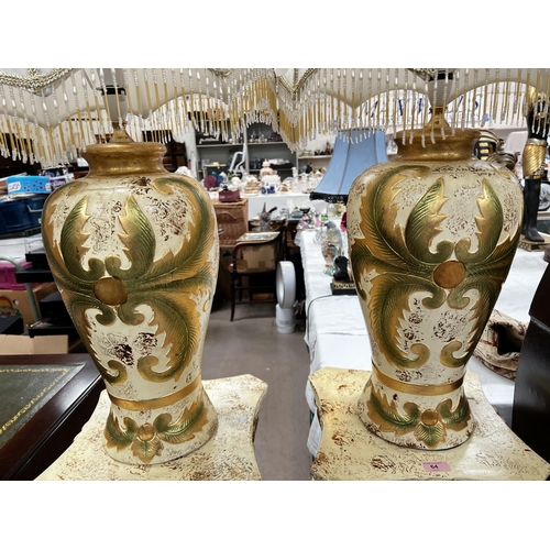 64 - A pair of classical columns in cream and gilt and matching table lamps