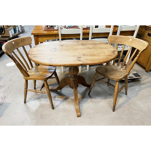 928 - A pine pedestal kitchen table and a pair of lathe back chairs