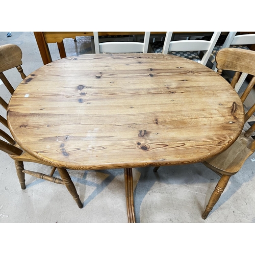 928 - A pine pedestal kitchen table and a pair of lathe back chairs