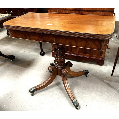 956 - A 19th Century mahogany fold over tea table on turned and ringed column, four splay feet and brass c... 