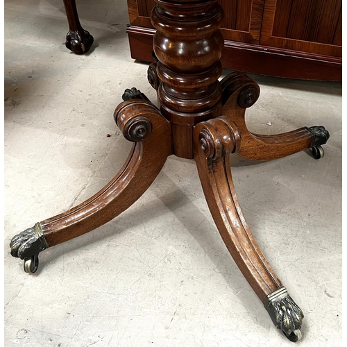 956 - A 19th Century mahogany fold over tea table on turned and ringed column, four splay feet and brass c... 