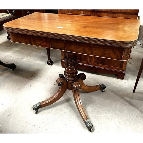 956 - A 19th Century mahogany fold over tea table on turned and ringed column, four splay feet and brass c... 