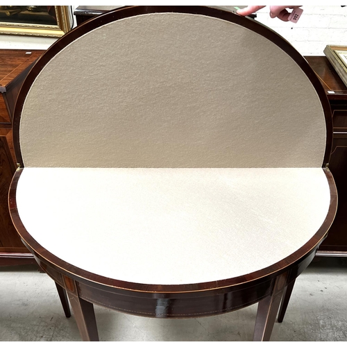 991 - A Sheraton style demi-lune inlaid mahogany card table with wide satinwood crossbanding and shell inl... 