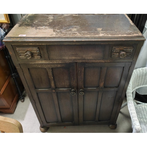 984 - An oak C.W.S tallboy with single drawer and double cupboard, and two traditional bed ends and irons