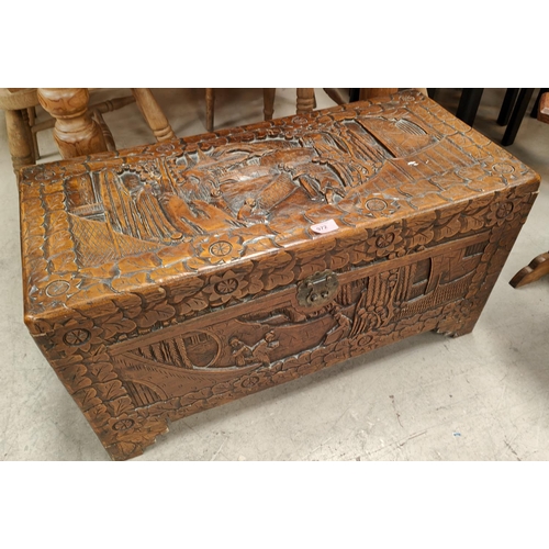 972 - An oriental camphor wood bedding box with extensive carved wood decoration, length