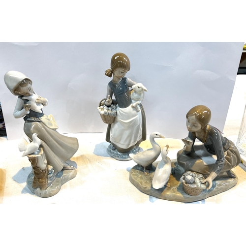 532 - A Lladro figure group of girl feeding geese, 24cm long, and two other Lladro figures.