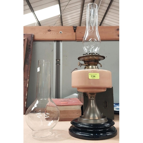 134 - A 19th century oil lamp with opaque reservoir and two glass chimneys.