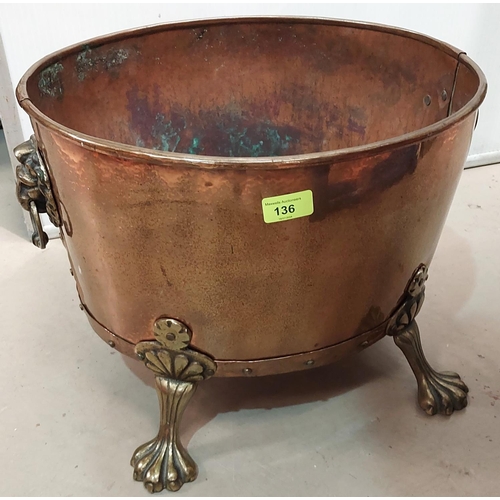 136 - An oval copper log box with brass lion mark handles and and paw feet.