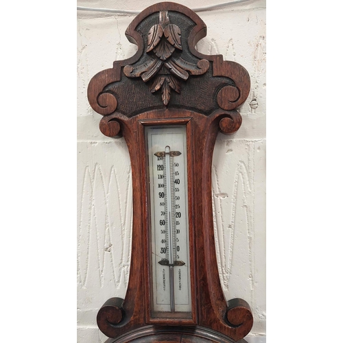 50 - A carved oak cased aneroid barometer with thermometer