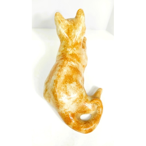 567 - A Winstanley cat, glass eyes, lying down, length 26cm, signed; another similar with glass eyes, sign... 