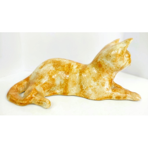 567 - A Winstanley cat, glass eyes, lying down, length 26cm, signed; another similar with glass eyes, sign... 