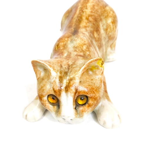 567 - A Winstanley cat, glass eyes, lying down, length 26cm, signed; another similar with glass eyes, sign... 