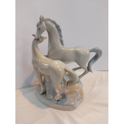 596 - A large Lladro style group of horse and foal.