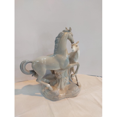 596 - A large Lladro style group of horse and foal.