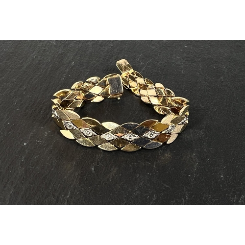 678 - A yellow metal bracelet formed from interlocking diamond shpaed links, bears foreign marks, tests as... 